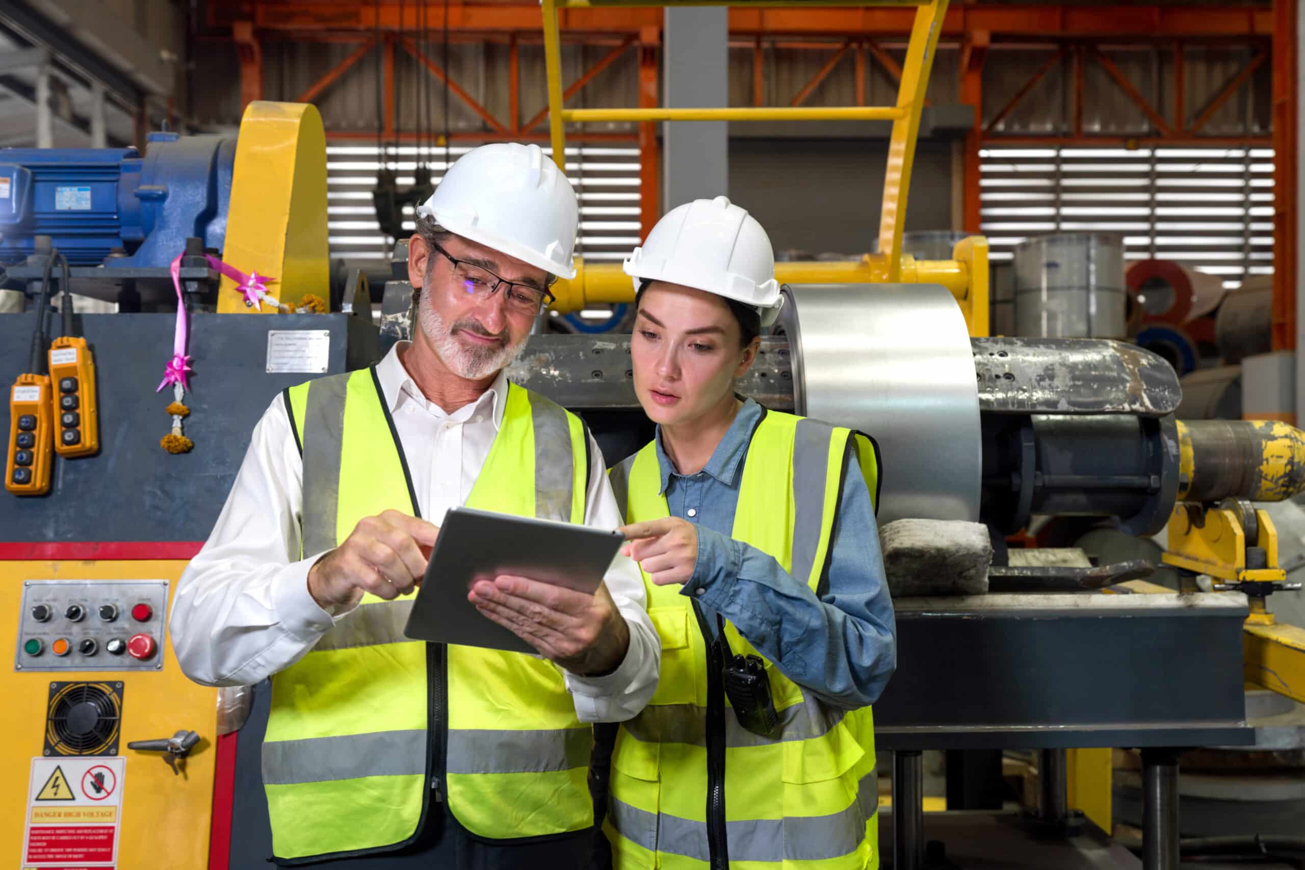 Opérateur en formation devant une machine avec une tablette
